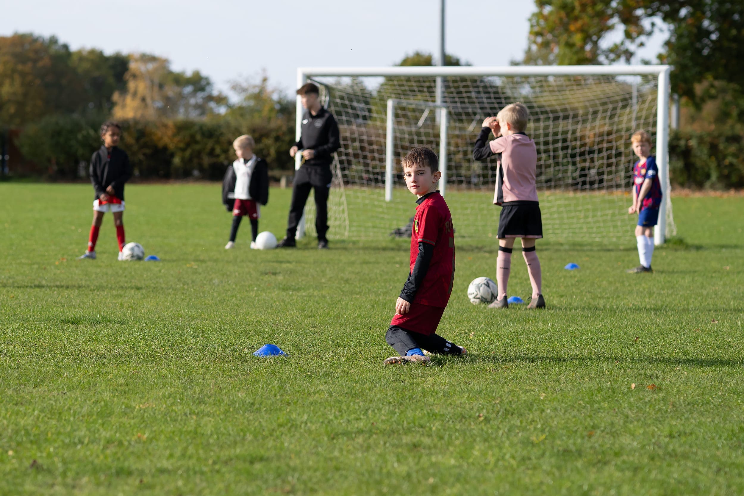 You Football palyers being coached in Mulbarton by Noah at an NH Football Coaching half term holiday camp.